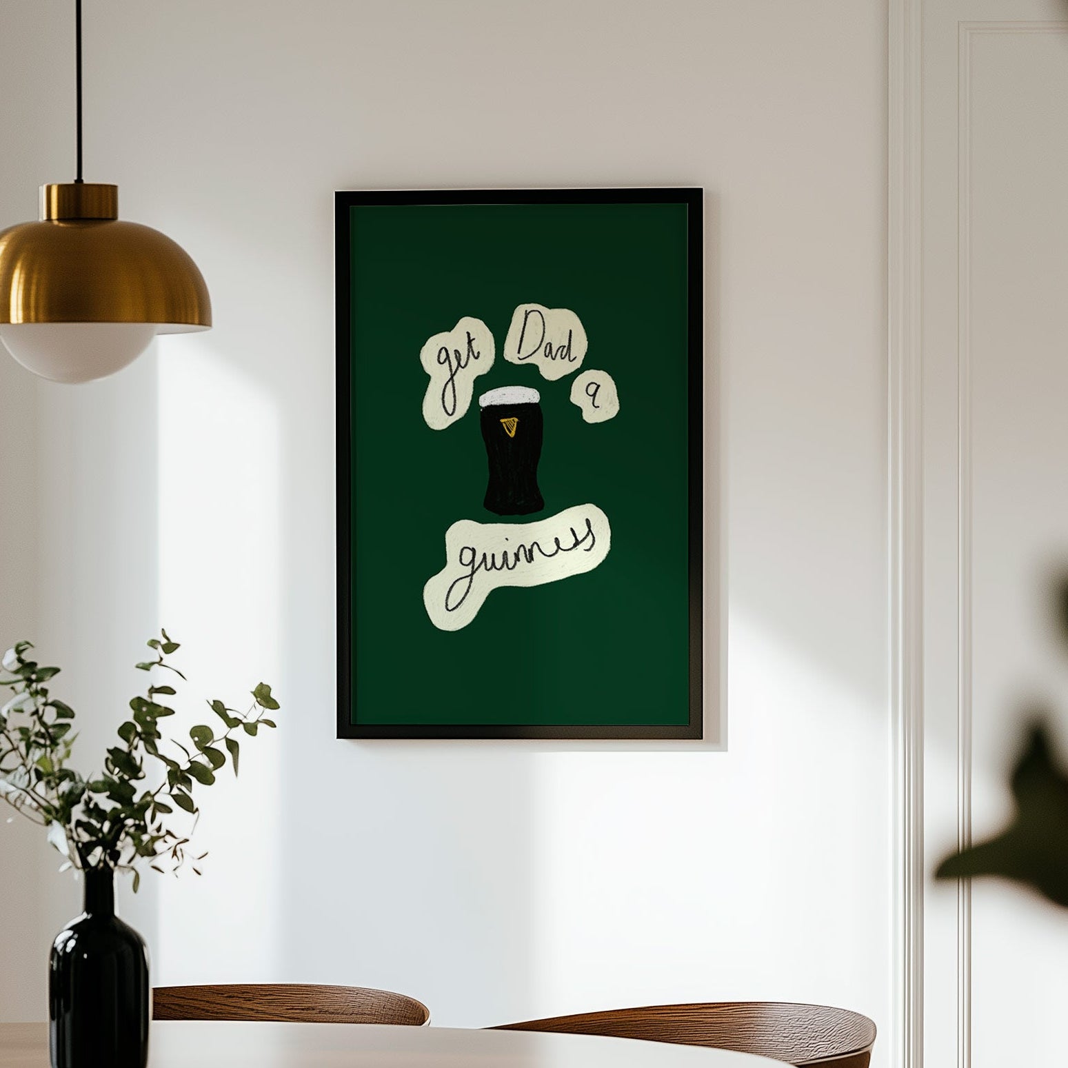 Framed artwork on a wall above a dining table with chairs.