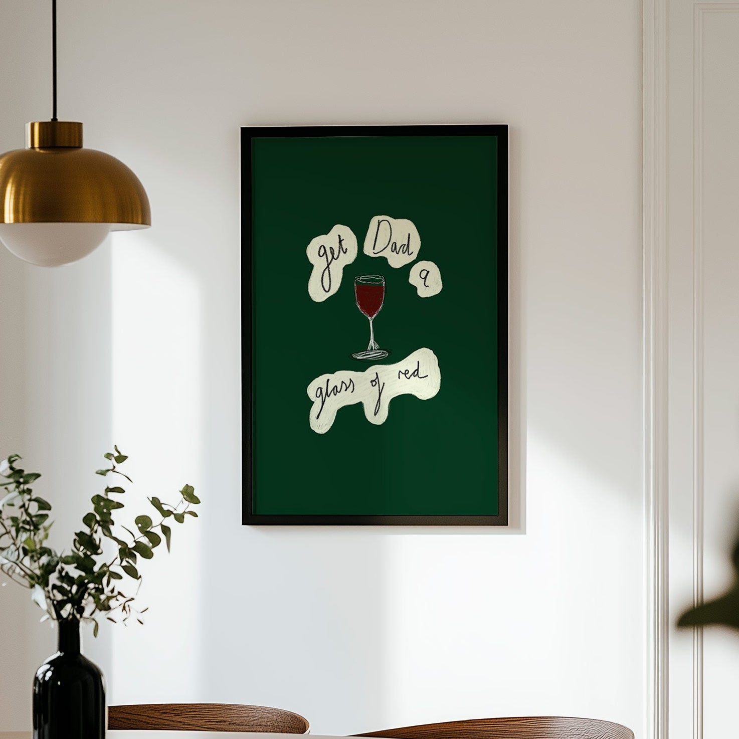 Framed artwork on a wall above a dining table with chairs.