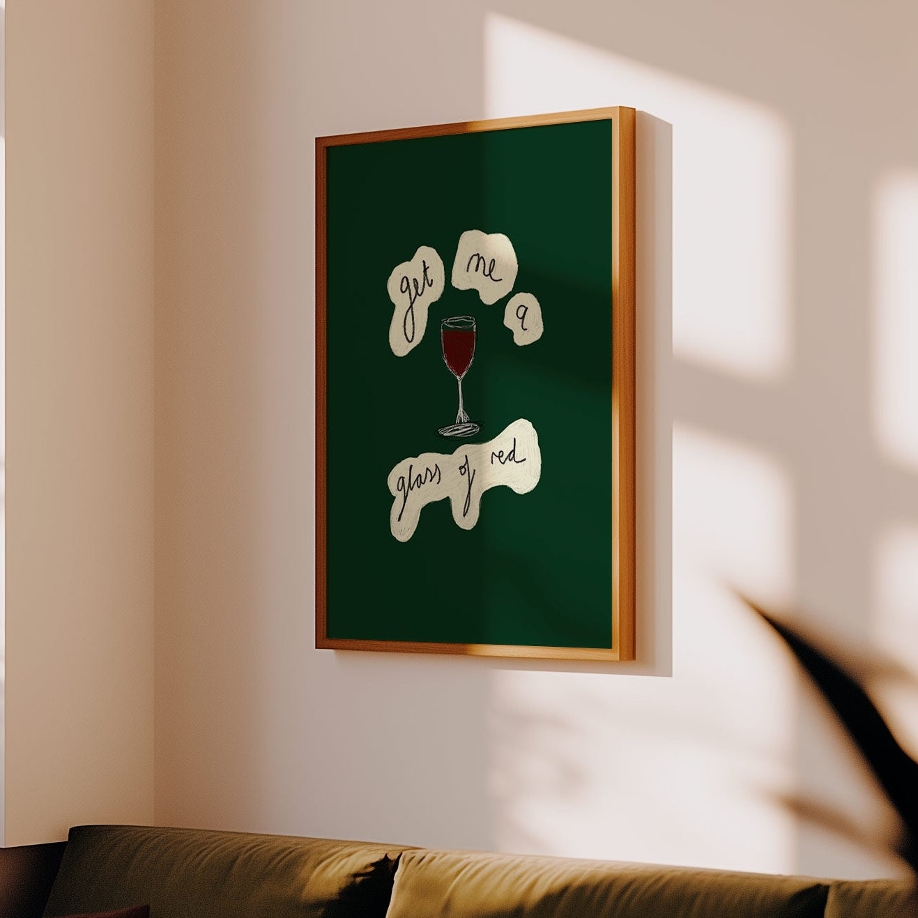 Framed artwork on a wall above a sofa in a sunlit room