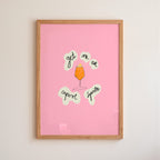 Framed pink poster with aperol spritz illustration and text on a beige wall.