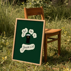 Framed green print get me a guinness on a wooden chair in a grassy outdoor setting