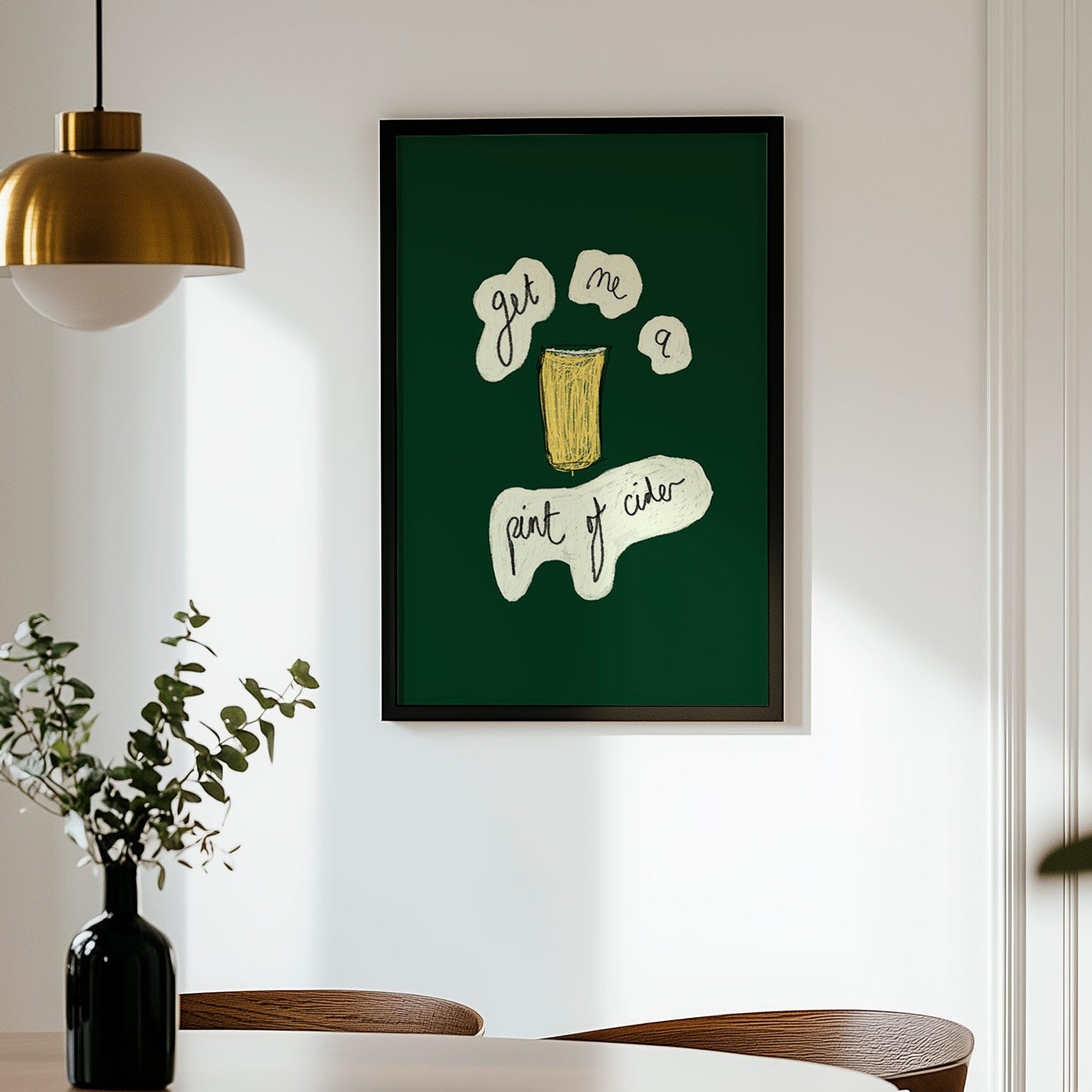 Framed artwork on a wall above a dining table with chairs.