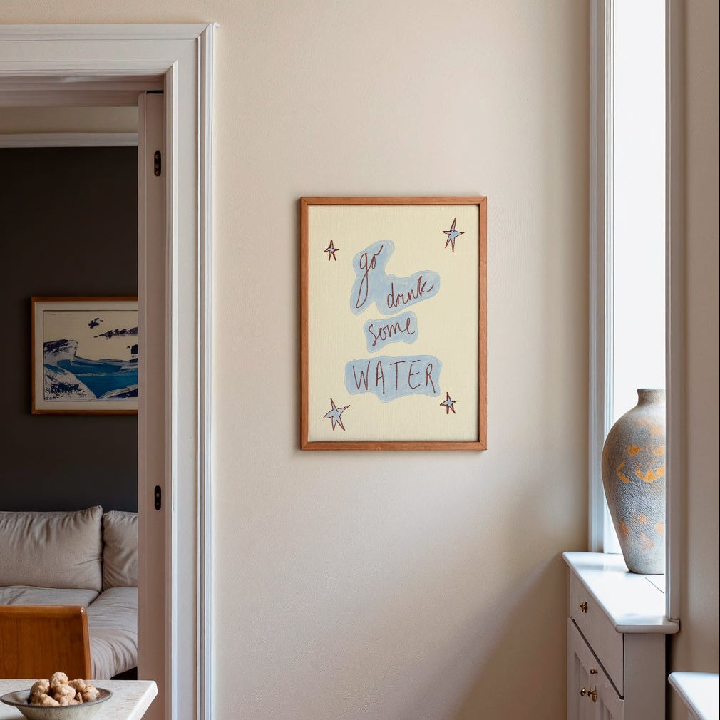 Cream blue frame 'go drink some water' in frame on wall in kitchen