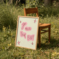 Wooden chair with a framed sign reading 'Go move your body' in a grassy outdoor setting.