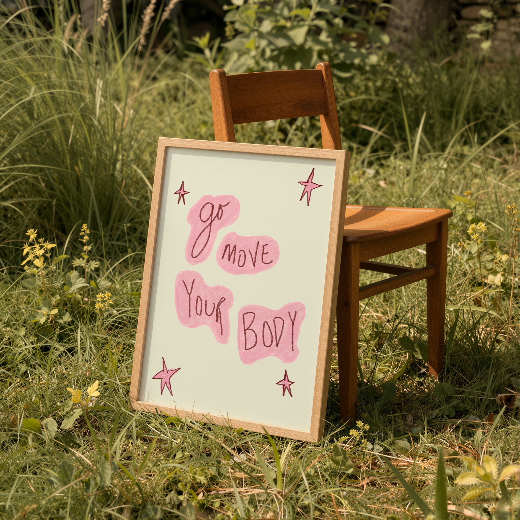 Wooden chair with a framed sign reading 'Go move your body' in a grassy outdoor setting.