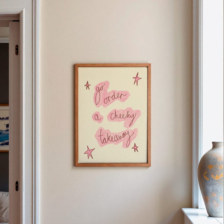 Frame on wall in kitchen with words 'go order a cheeky takeaway' in red and cream