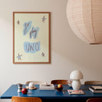 Dining room with a blue table, wooden chairs, and a framed poster on the wall.
