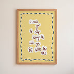Yellow motivational 'be who you are' poster in a frame on white wall