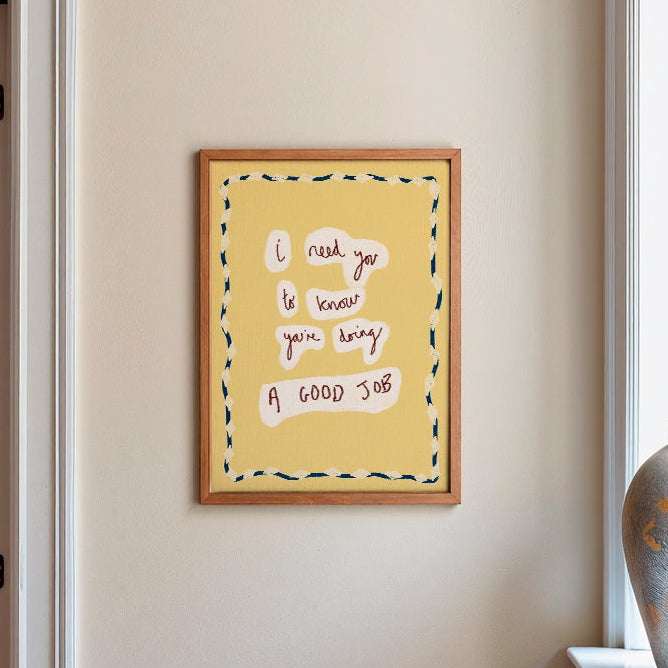 Motivational print in yellow in frame on plain wall in kitchen