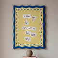 Framed quote on a wall with books and a sphere on a pedestal below.