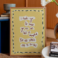 Framed motivational quote on a yellow background in a home setting with decor elements.