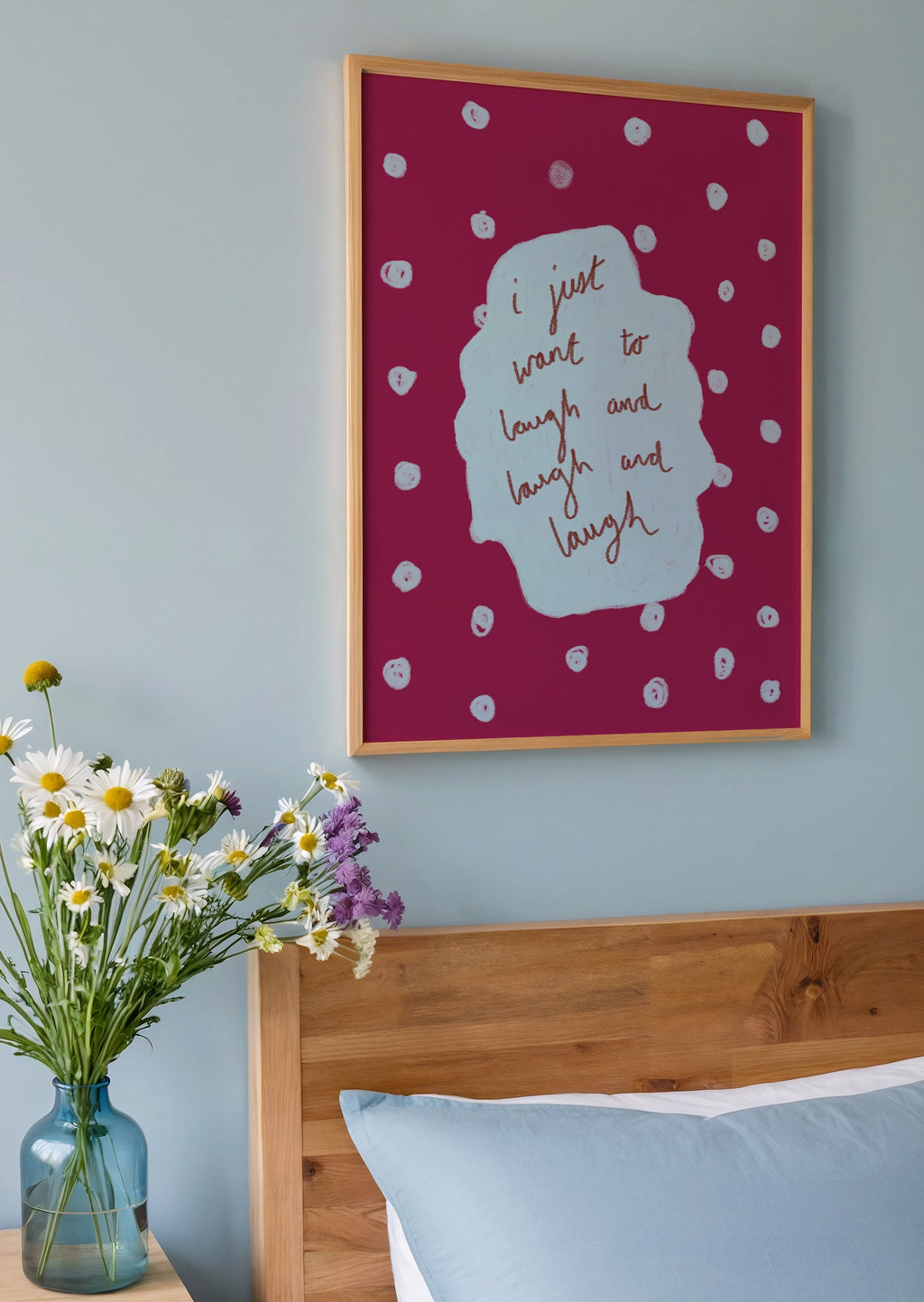 Bedroom with wooden headboard, blue pillows, and a vase of flowers on a nightstand.