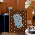 Decorative framed print with text and polka dots in a home setting