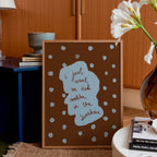 Decorative framed print with text and polka dots in a home setting