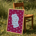 Purple and blue print with words 'i just want to read my book in the sunshine' in frame against chair outside