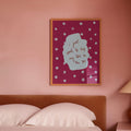 Bedroom with pink walls, a bed, and a lamp on a nightstand.
