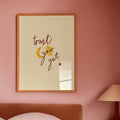 Bedroom with pink walls, a bed, and a framed quote on the wall with the words trust your gut.