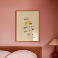 Bedroom with pink walls, a bed, and a framed quote on the wall which says trust in the moon, in the stars, iin the Sun