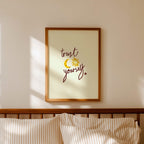 Bedroom with striped bedding, wooden headboard, and framed artwork on the wall with words 'trust yourself' on print